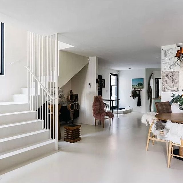 A living room with stairs and a table and chairs