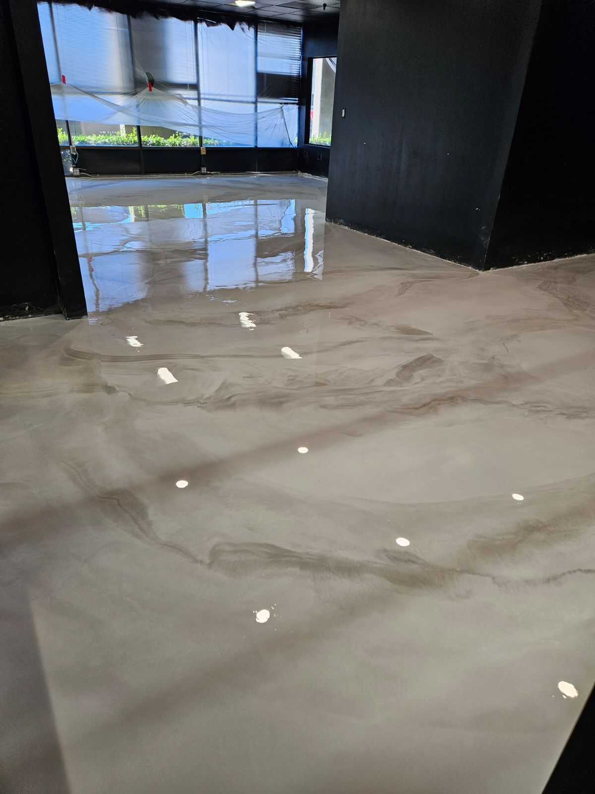 A room with a marble floor and a lot of windows.