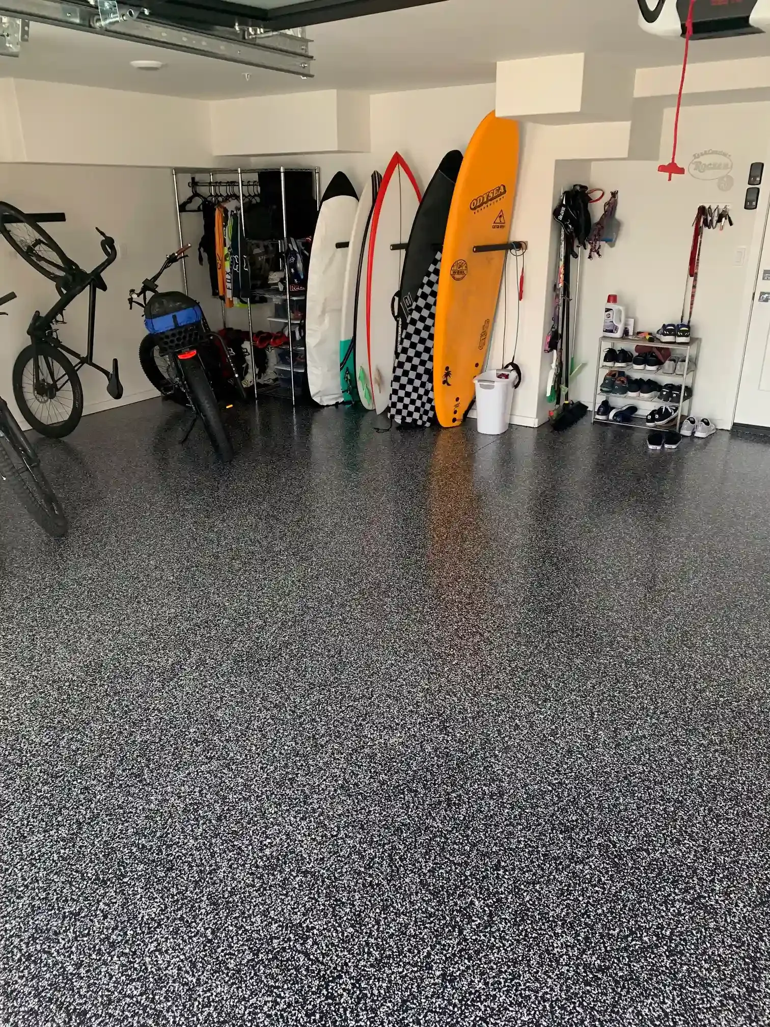 A garage filled with lots of surfboards and bikes.