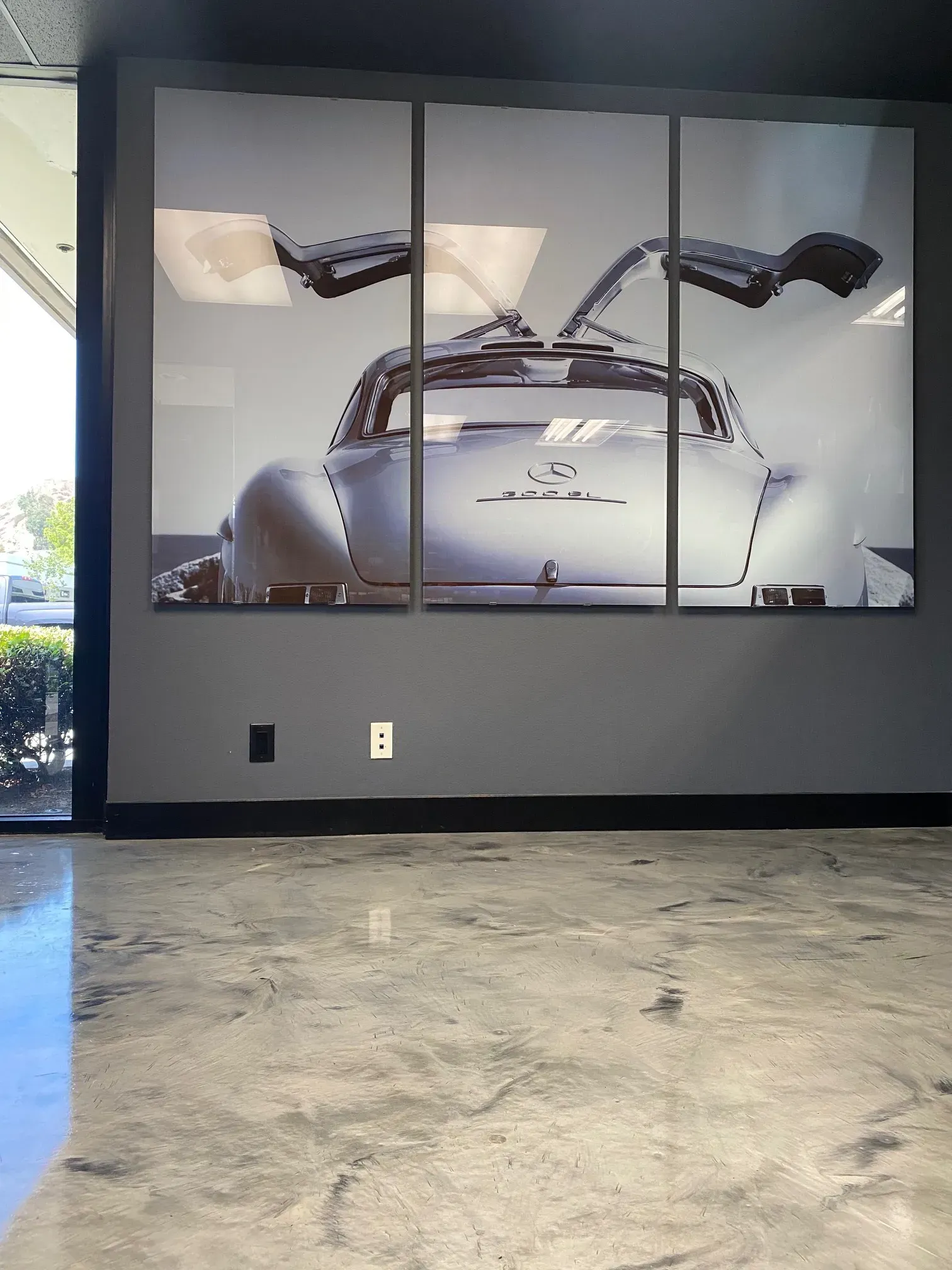 A large painting of a car with the wings open