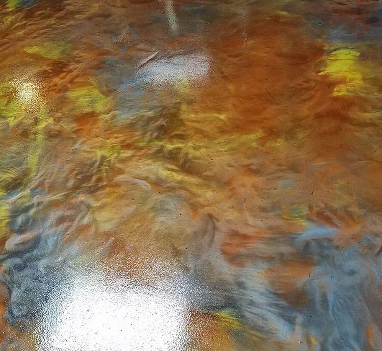 A close up of a painting on a concrete floor.