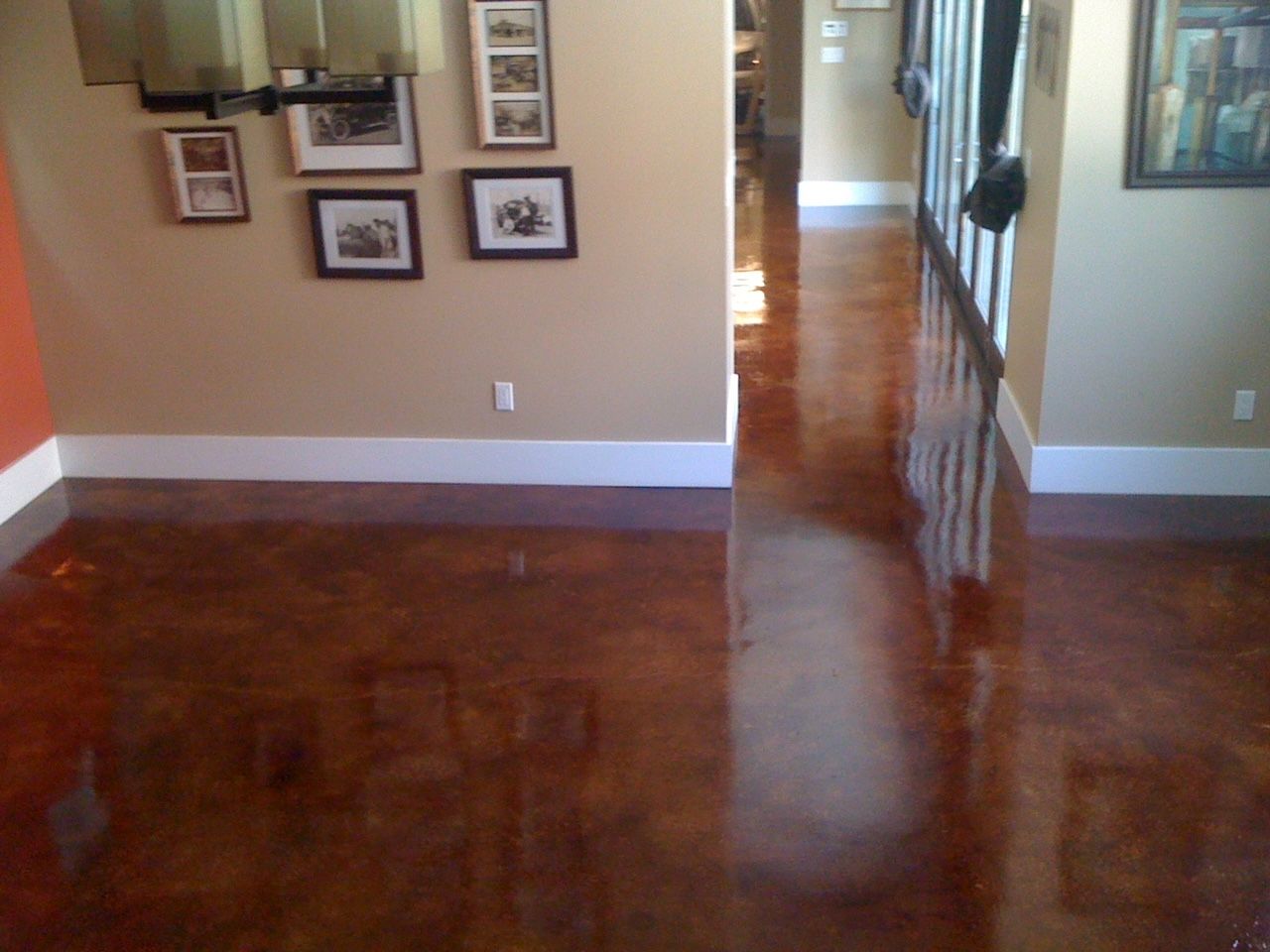 A hallway with pictures on the wall and a shiny floor
