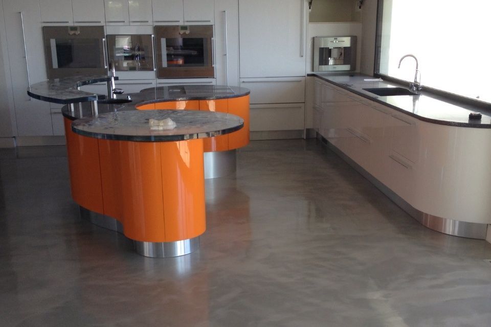 A kitchen with orange cabinets and black counter tops