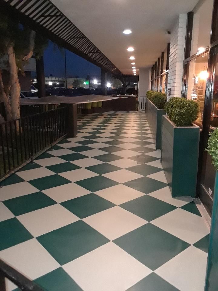 A walkway with green and white checkered tiles