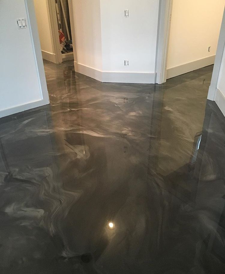 A black metallic floor in a room with white walls.