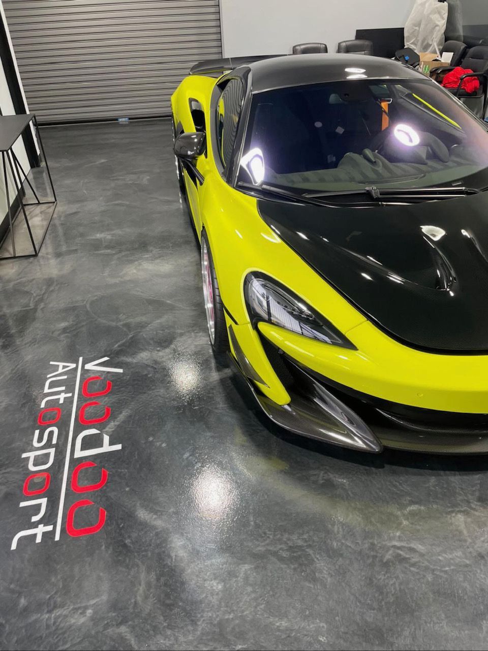 A yellow and black sports car is parked in a garage