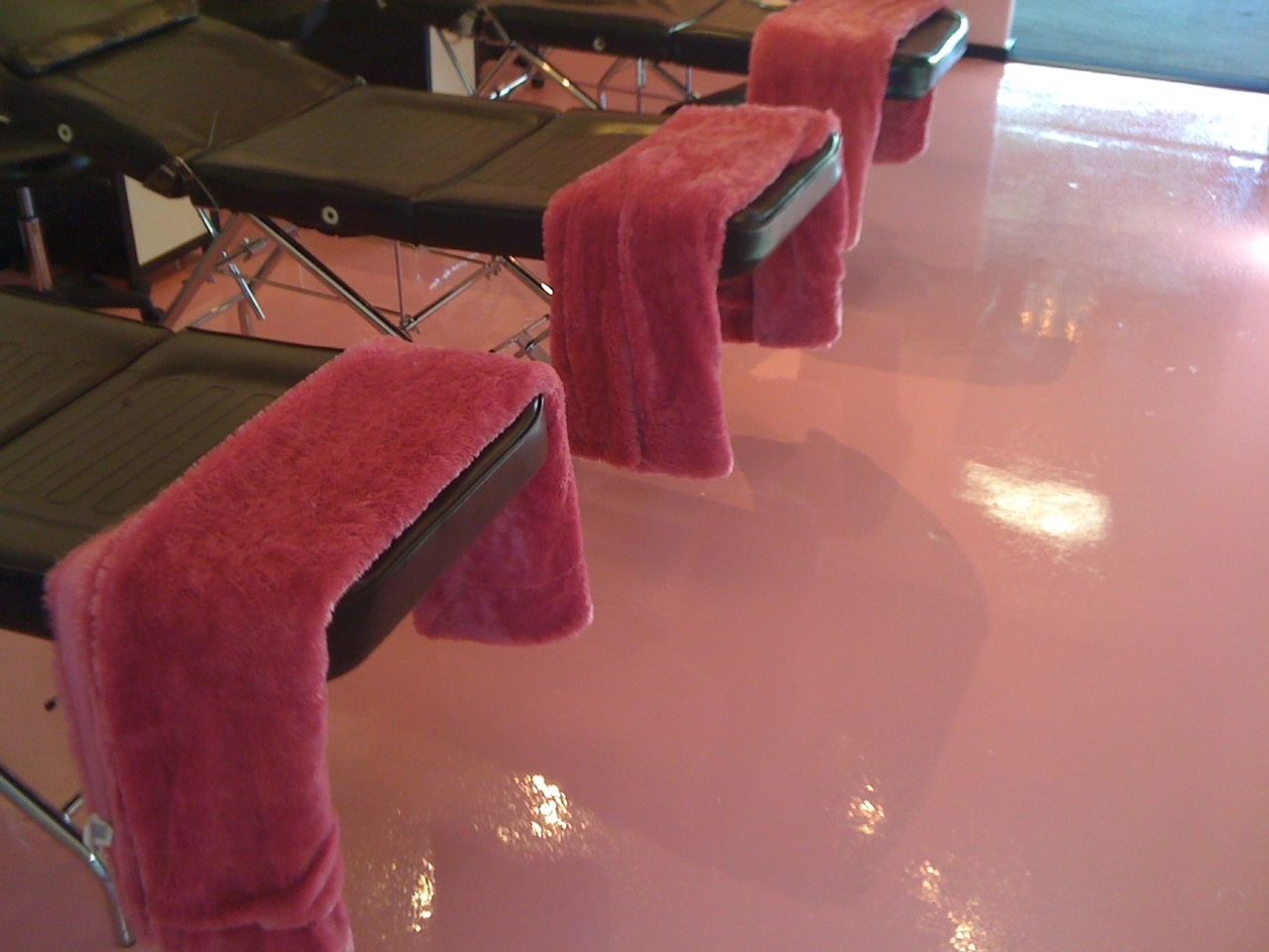A row of chairs with pink towels on them