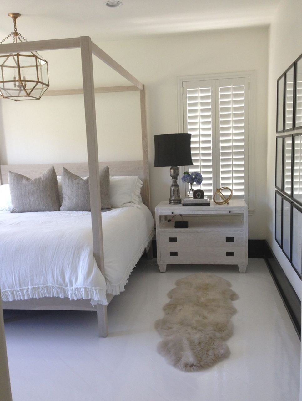 A bedroom with a four poster bed and a nightstand