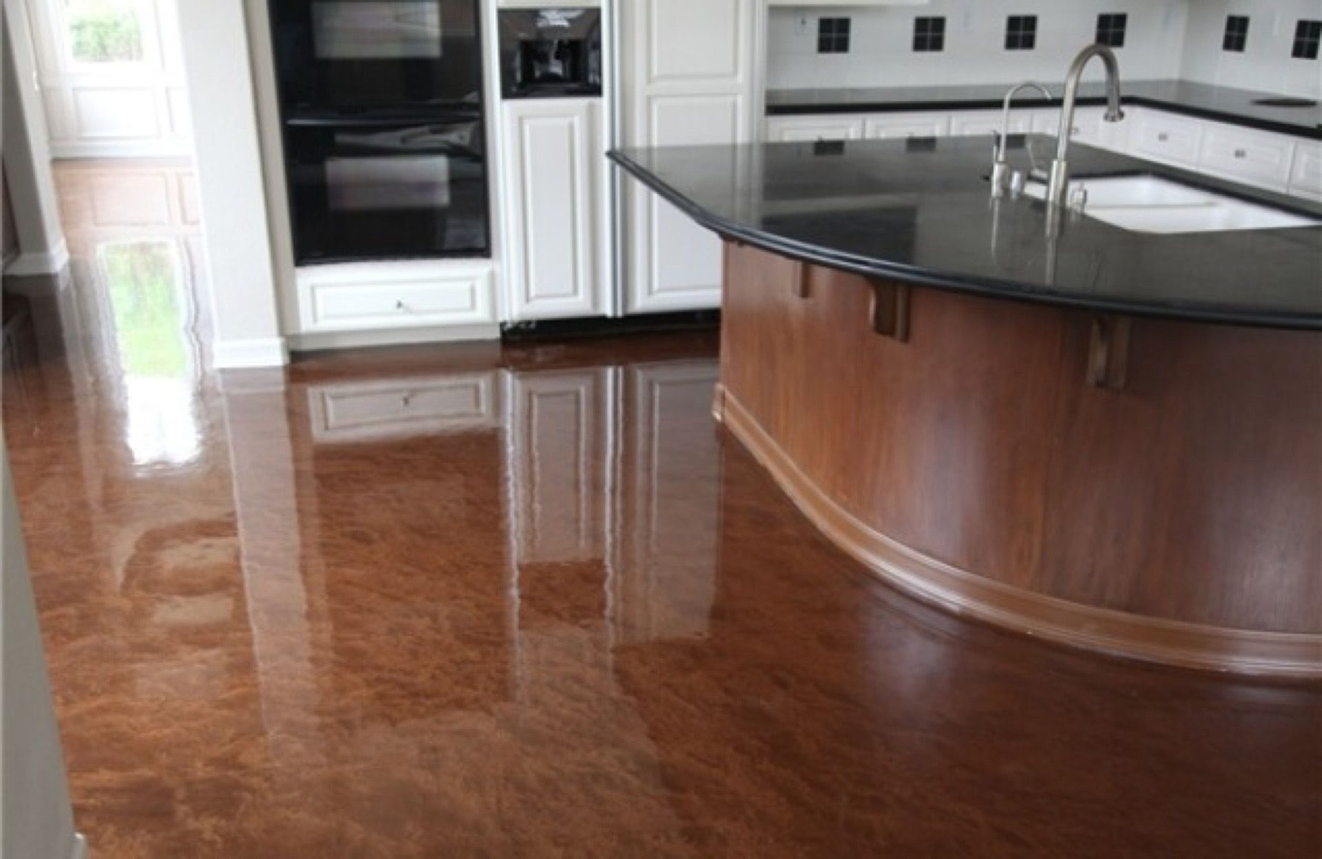 A kitchen with a large island and a black counter top.