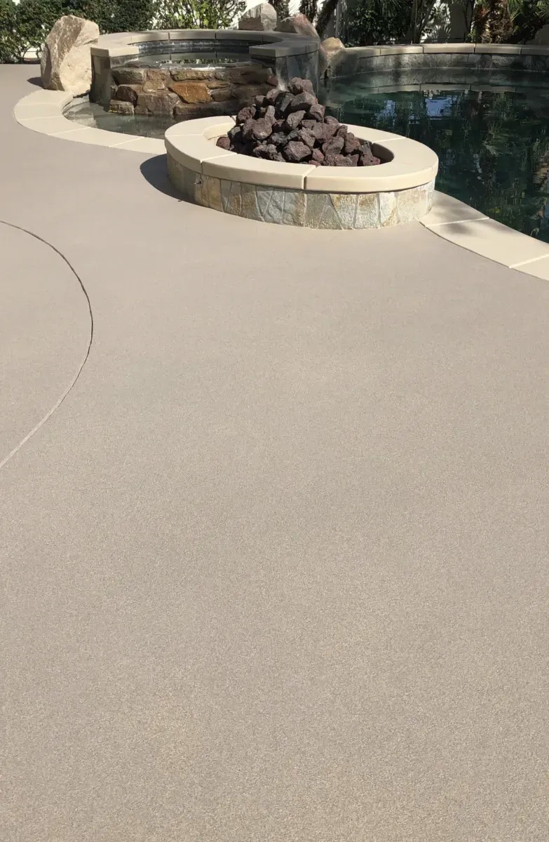 A fire pit is sitting next to a swimming pool.