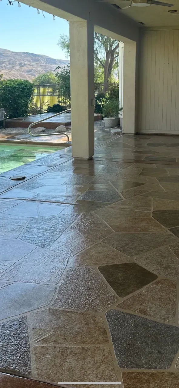 A patio with a pool and mountains in the background.