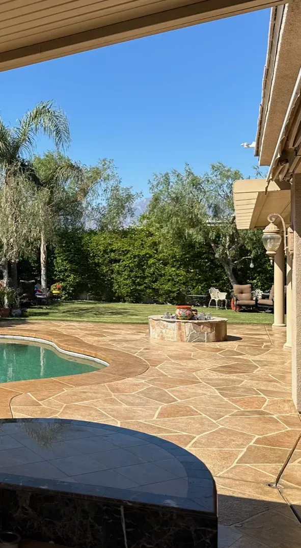 There is a swimming pool in the backyard of a house.