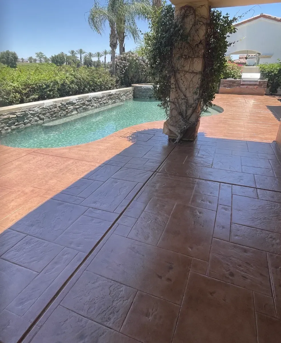 A patio with a swimming pool in the background