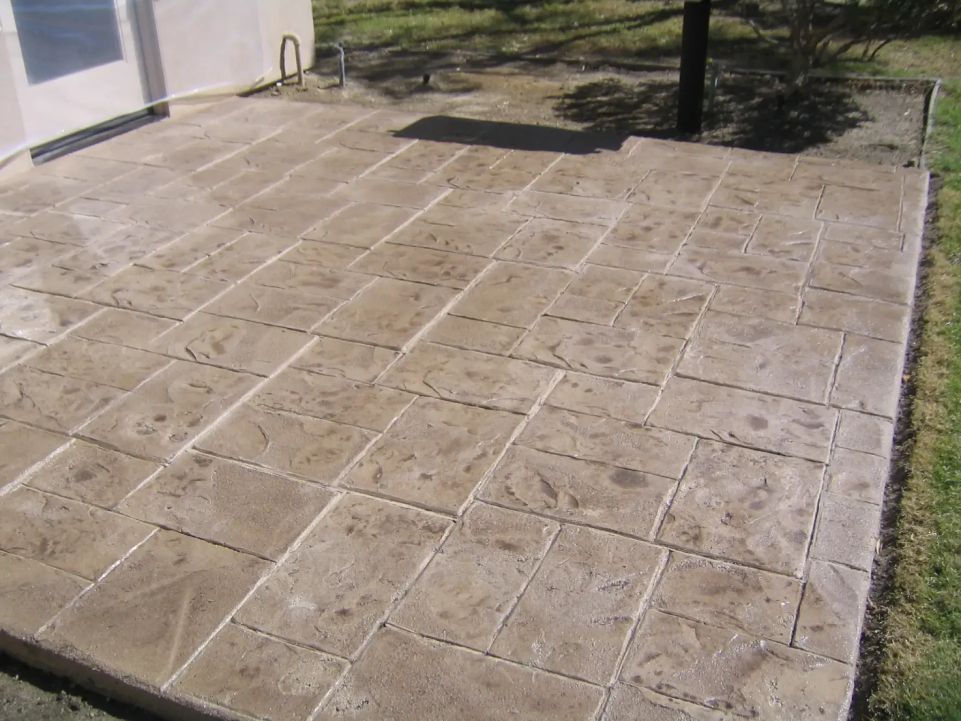 A concrete patio with a tree in the background