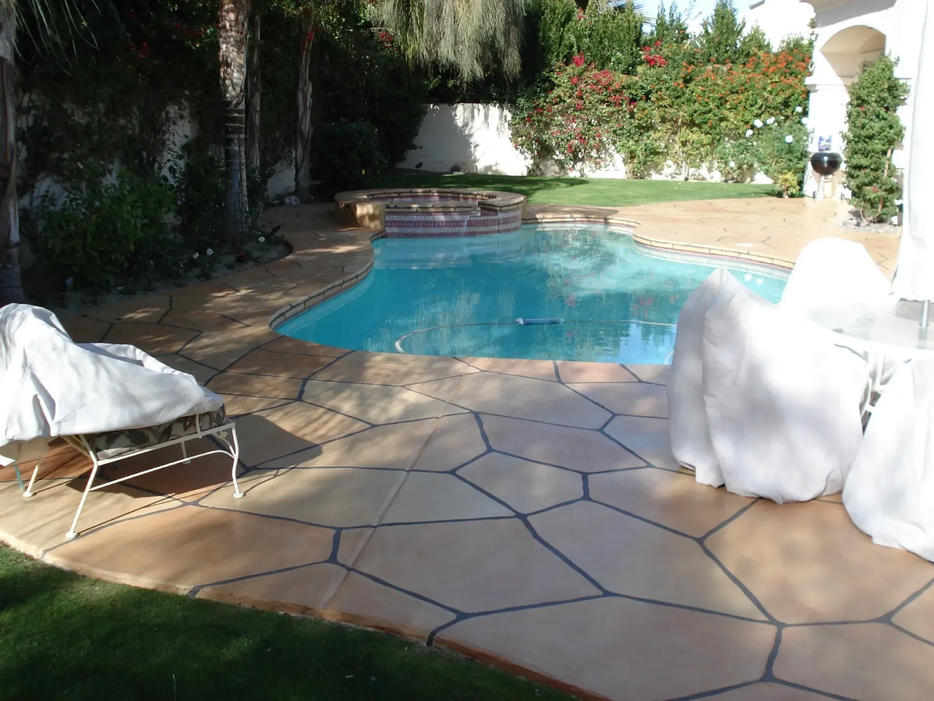 A woman in a white dress stands in front of a swimming pool