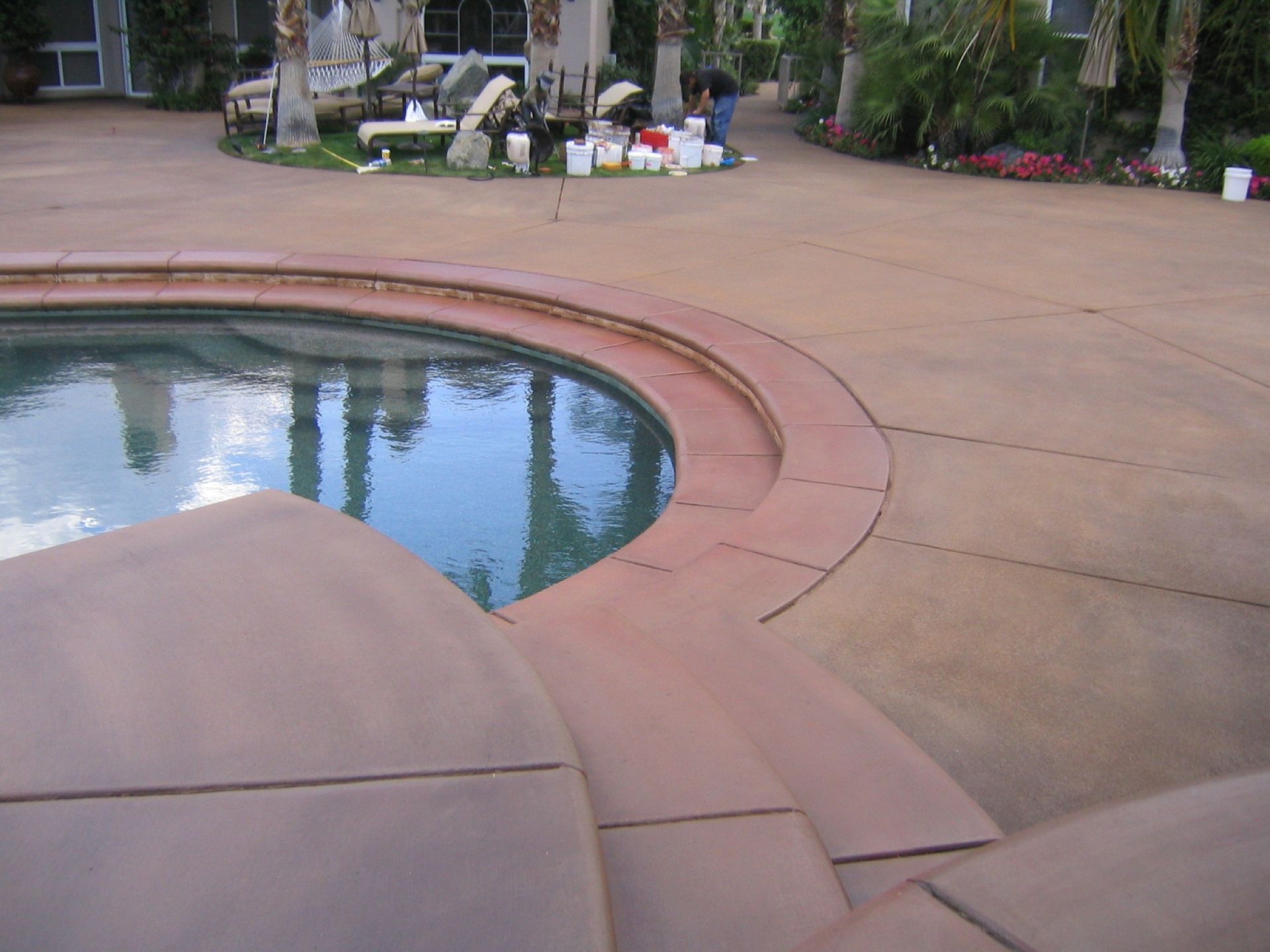 A circular swimming pool with a concrete patio in front of it