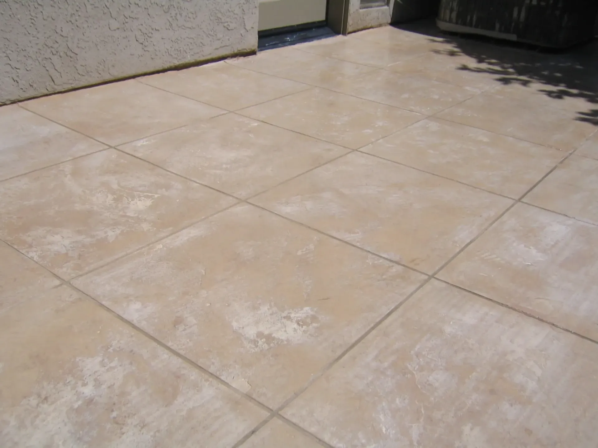 A tiled floor with a shadow of a tree on it