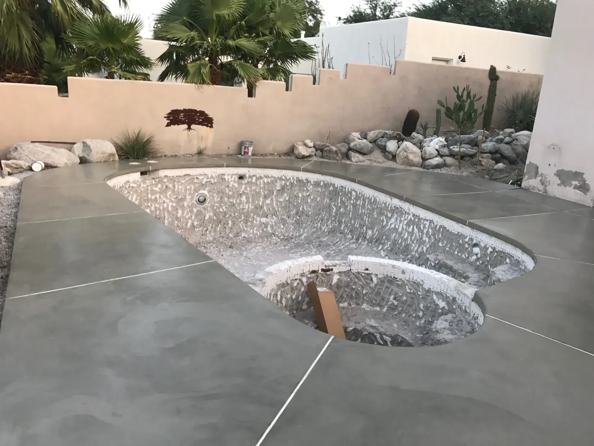 A large swimming pool is being built in a backyard.