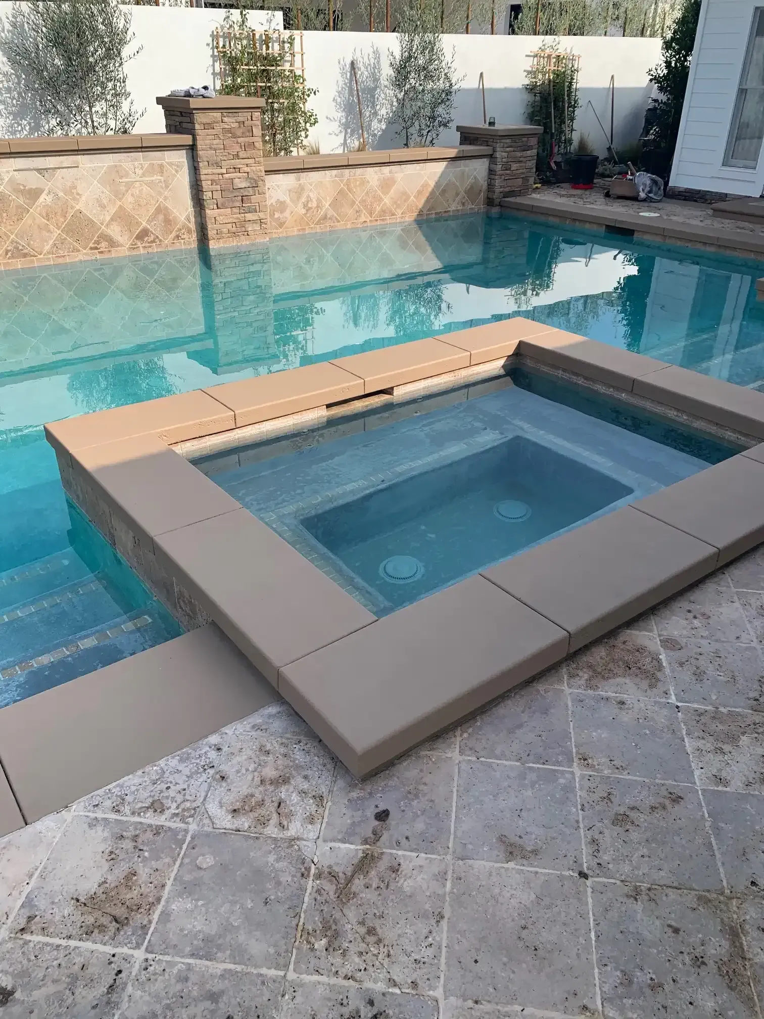 A swimming pool with a hot tub in the middle of it.