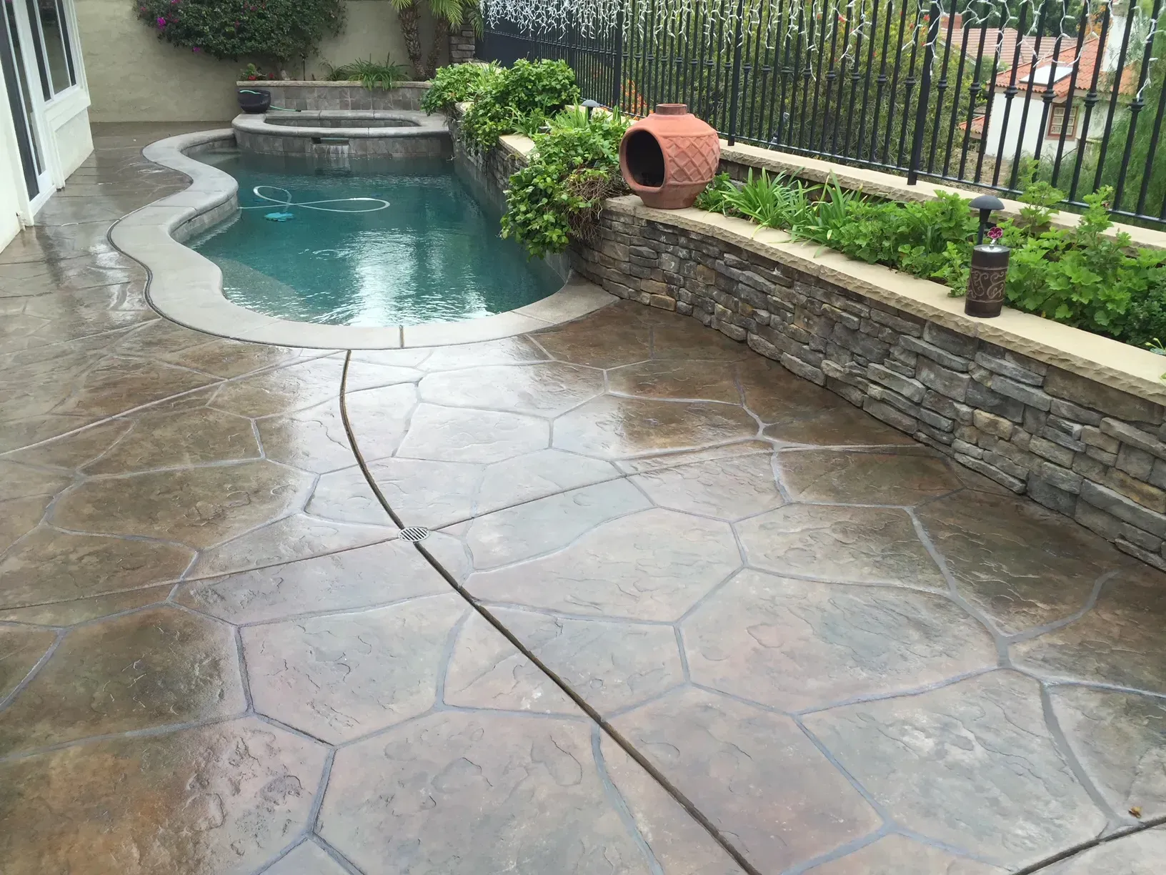 A patio with a swimming pool in the background
