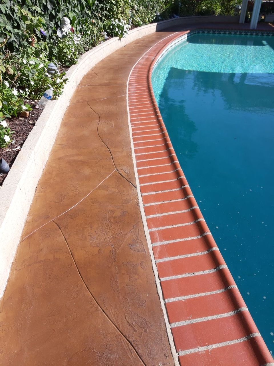 A brick walkway leading to a swimming pool