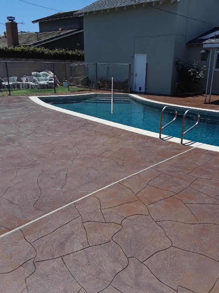 A large swimming pool is surrounded by a concrete deck