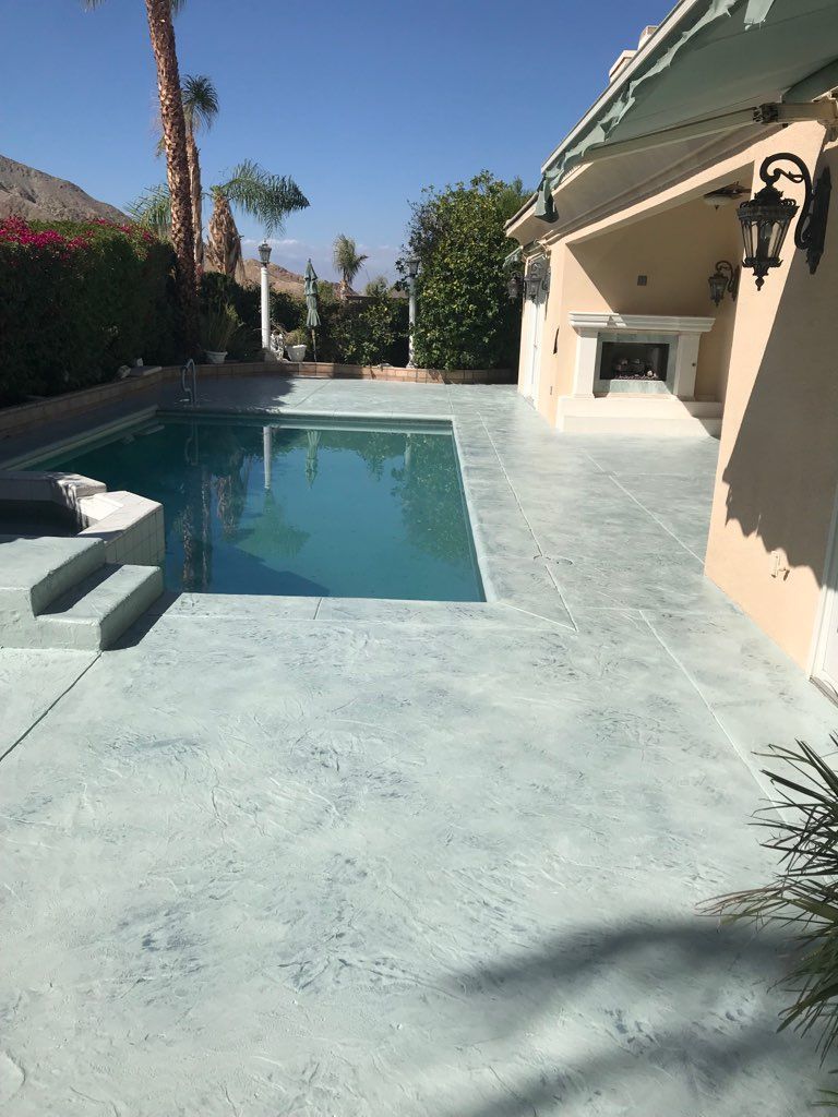 There is a large swimming pool in the backyard of a house.