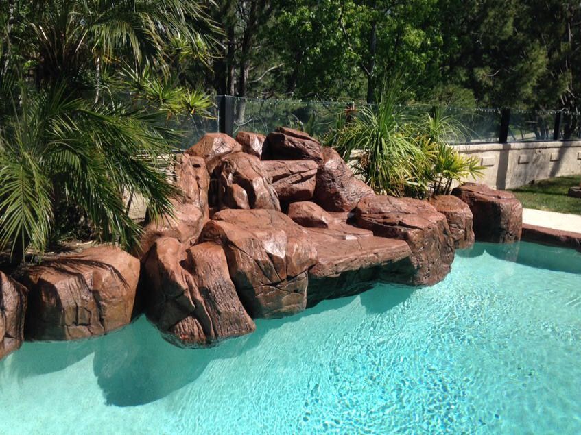 A swimming pool with a waterfall in the middle of it