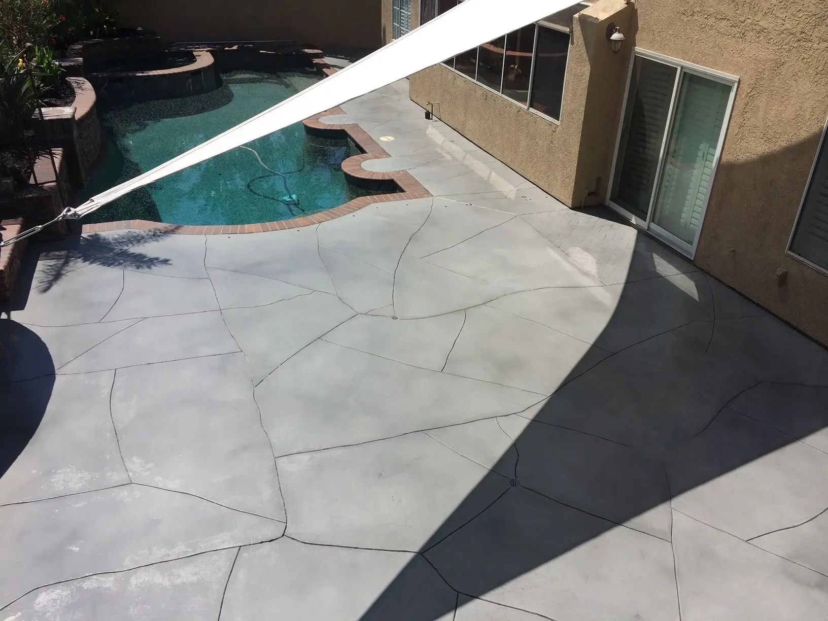 A patio with a swimming pool in the background