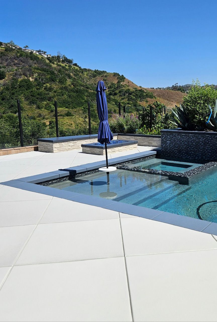 A large swimming pool with a purple umbrella in the middle of it.