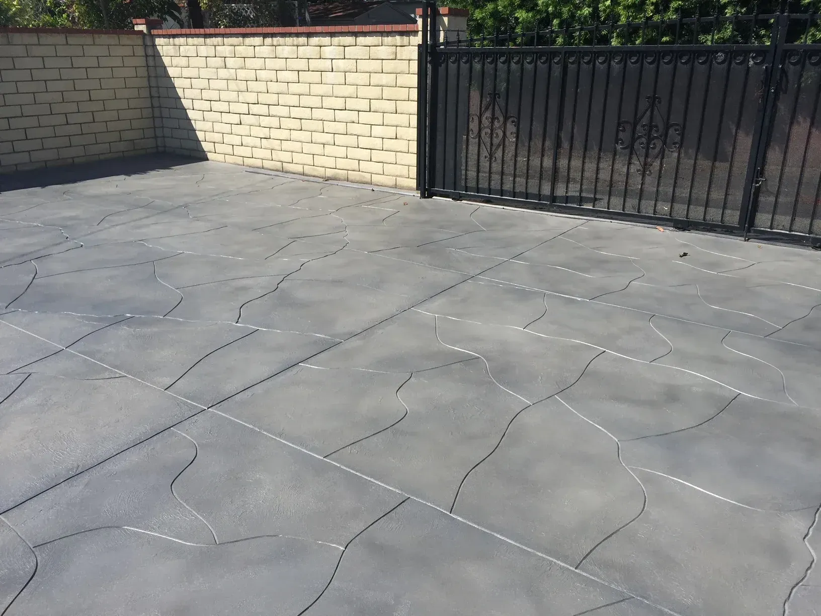 A concrete driveway with a fence in the background