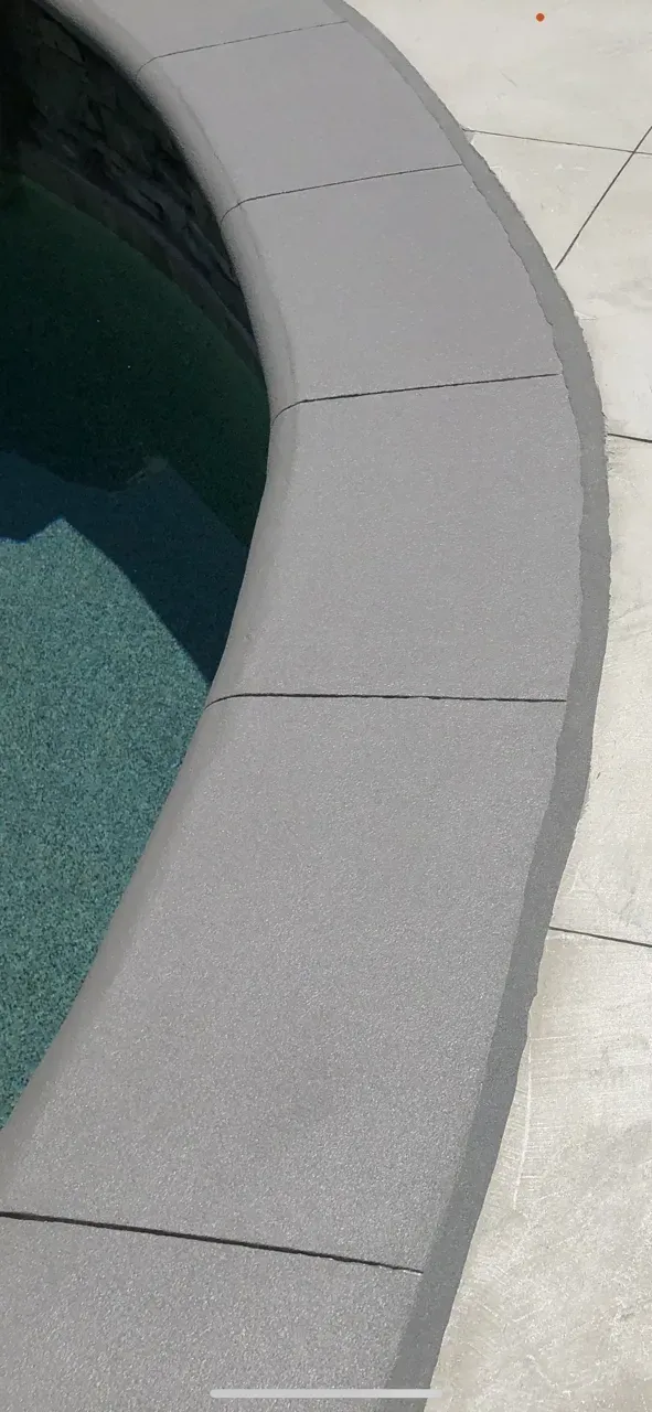 A close up of the edge of a swimming pool.