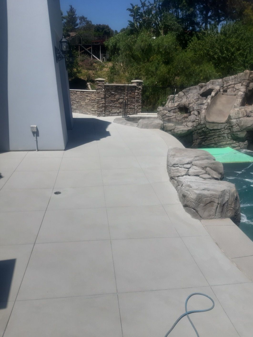A concrete walkway leading to a swimming pool
