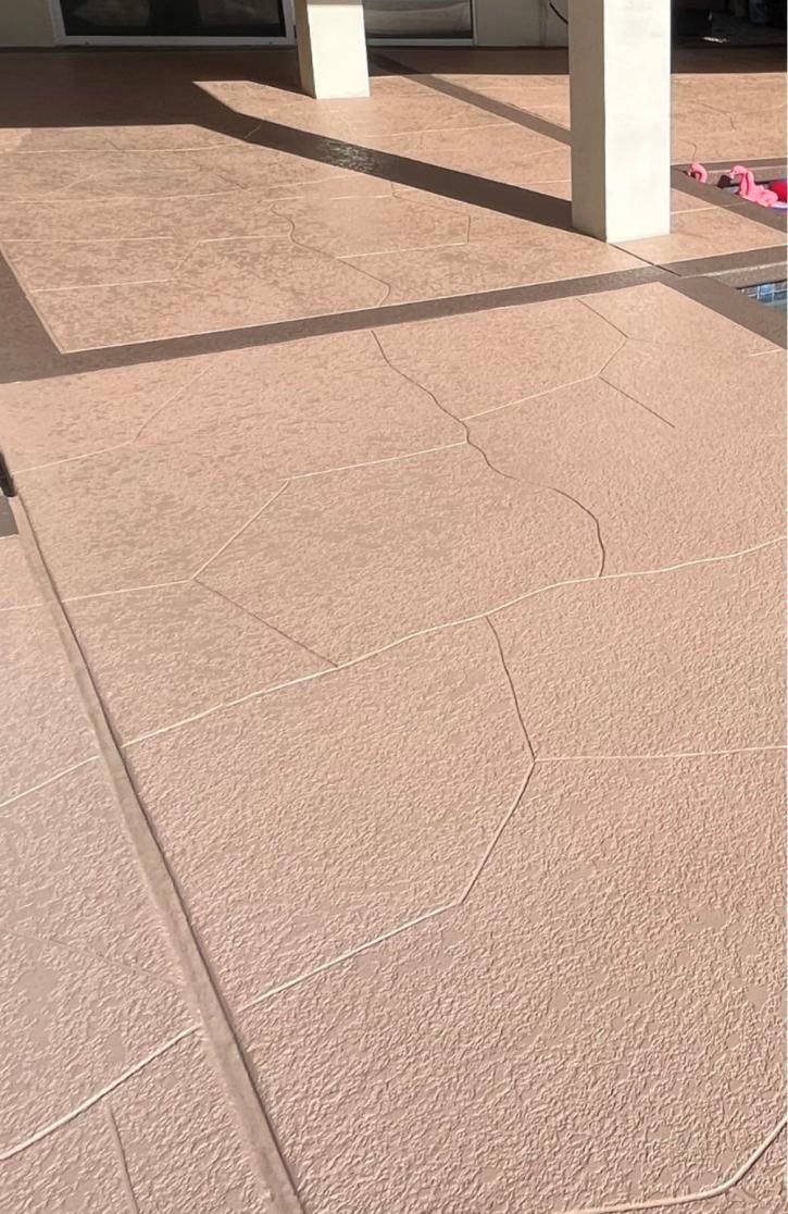 A patio with a concrete floor and pillars in the background.