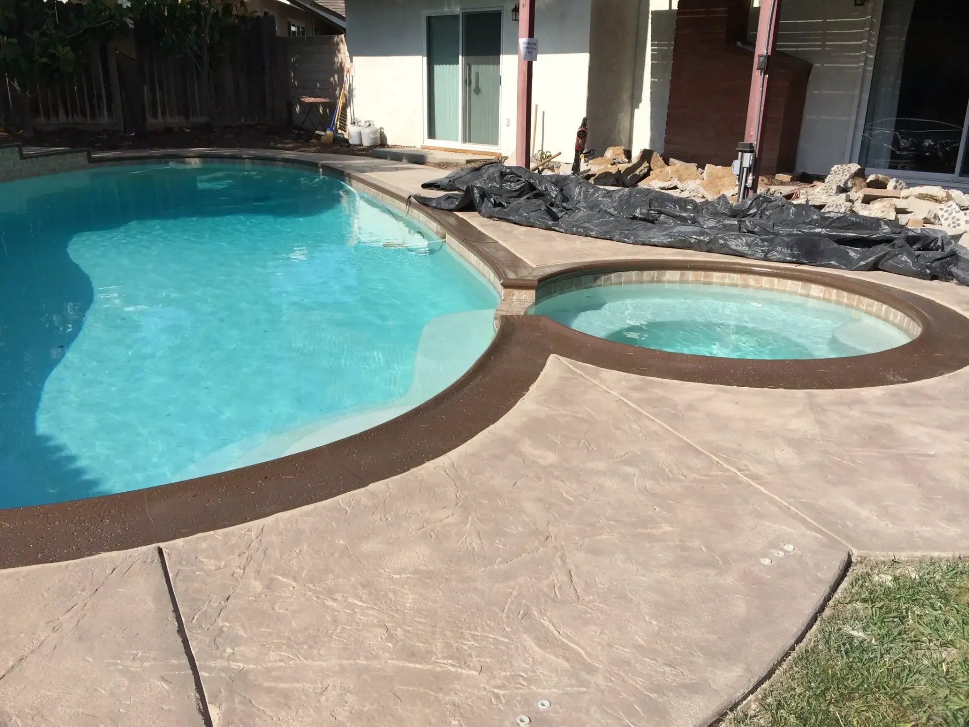 A swimming pool with a hot tub next to it