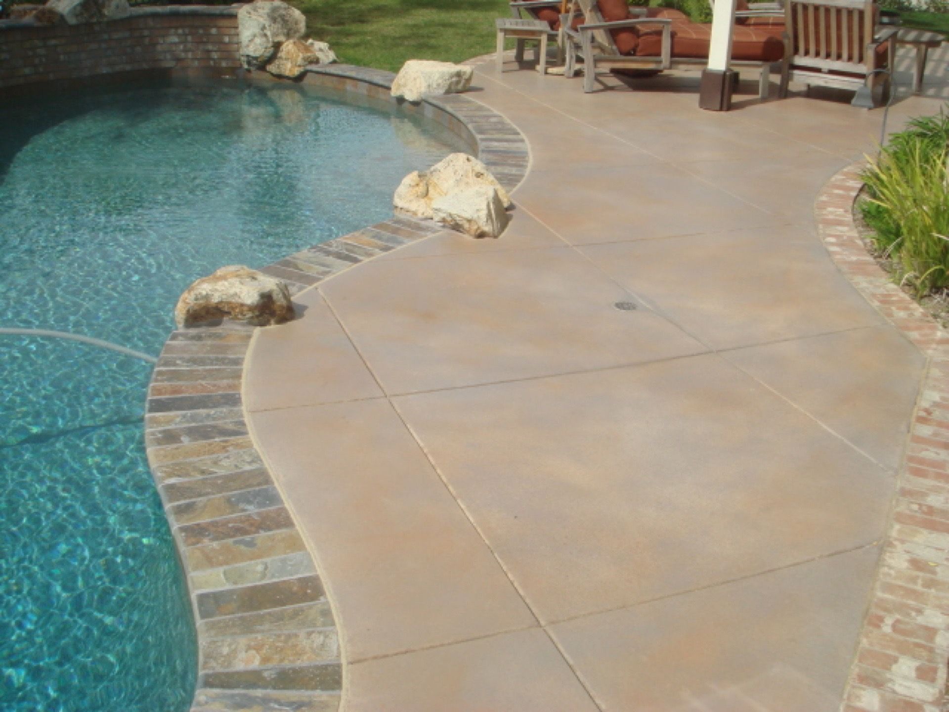 A patio with a swimming pool in the background