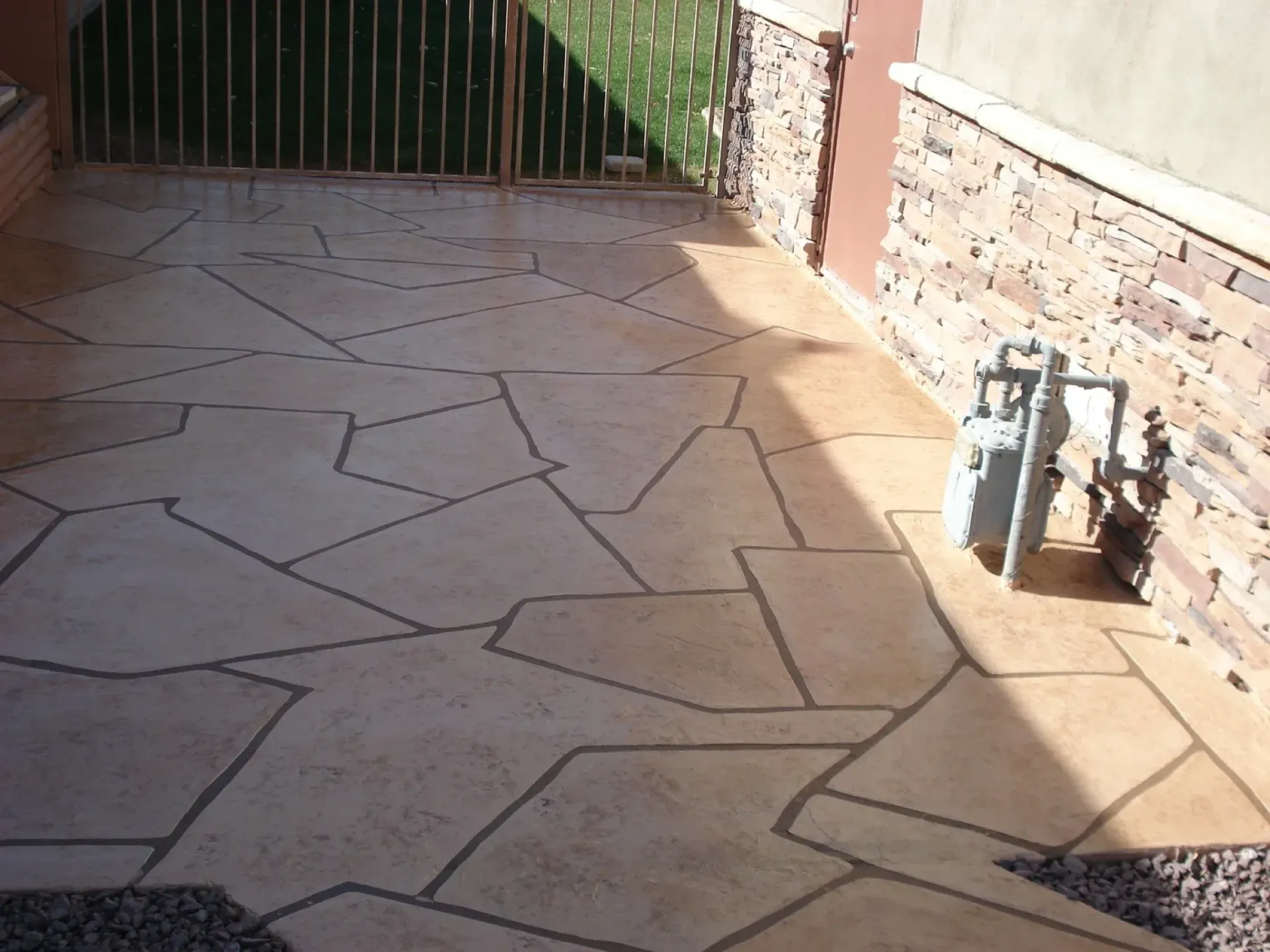 A concrete patio with a fence in the background