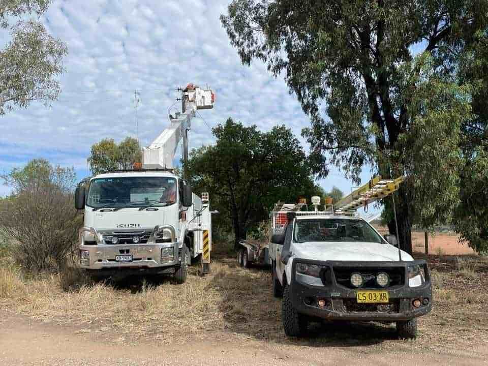 Two Trucks Are Parked Next to Each Other on A Dirt Road — Bay Coast Electrical & Control Solutions in Maloneys Beach, NSW