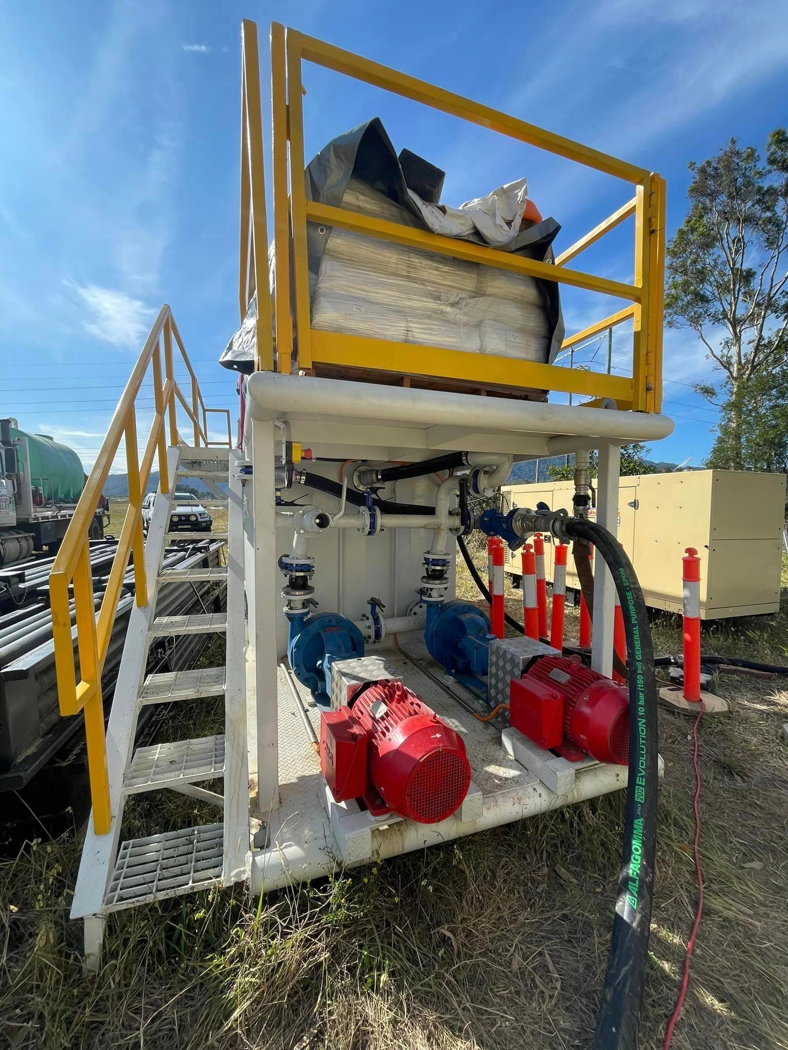 A Machine With Stairs And A Yellow Railing Is Sitting In A Field — BayCoast Electrical & Control Solutions in Braidwood, NSW