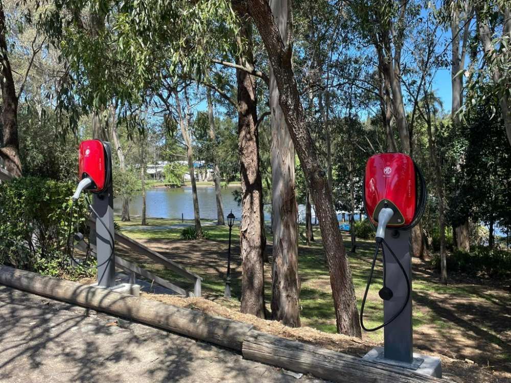 Two Red Telephone Booths Are Sitting Next To Each Other In A Park — BayCoast Electrical & Control Solutions In Broulee, NSW