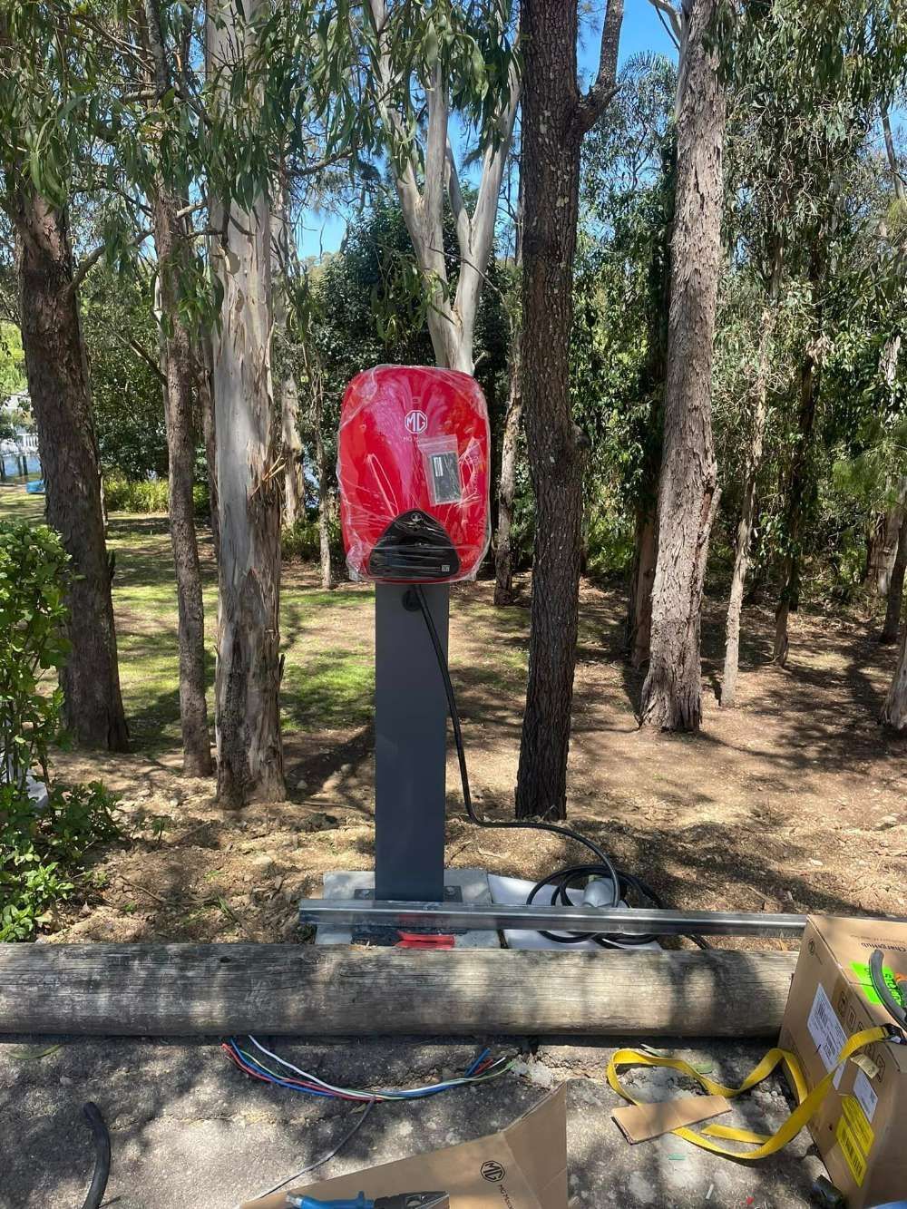 A Red Telephone Booth Is Sitting In The Middle Of A Forest — BayCoast Electrical & Control Solutions In South Durras, NSW
