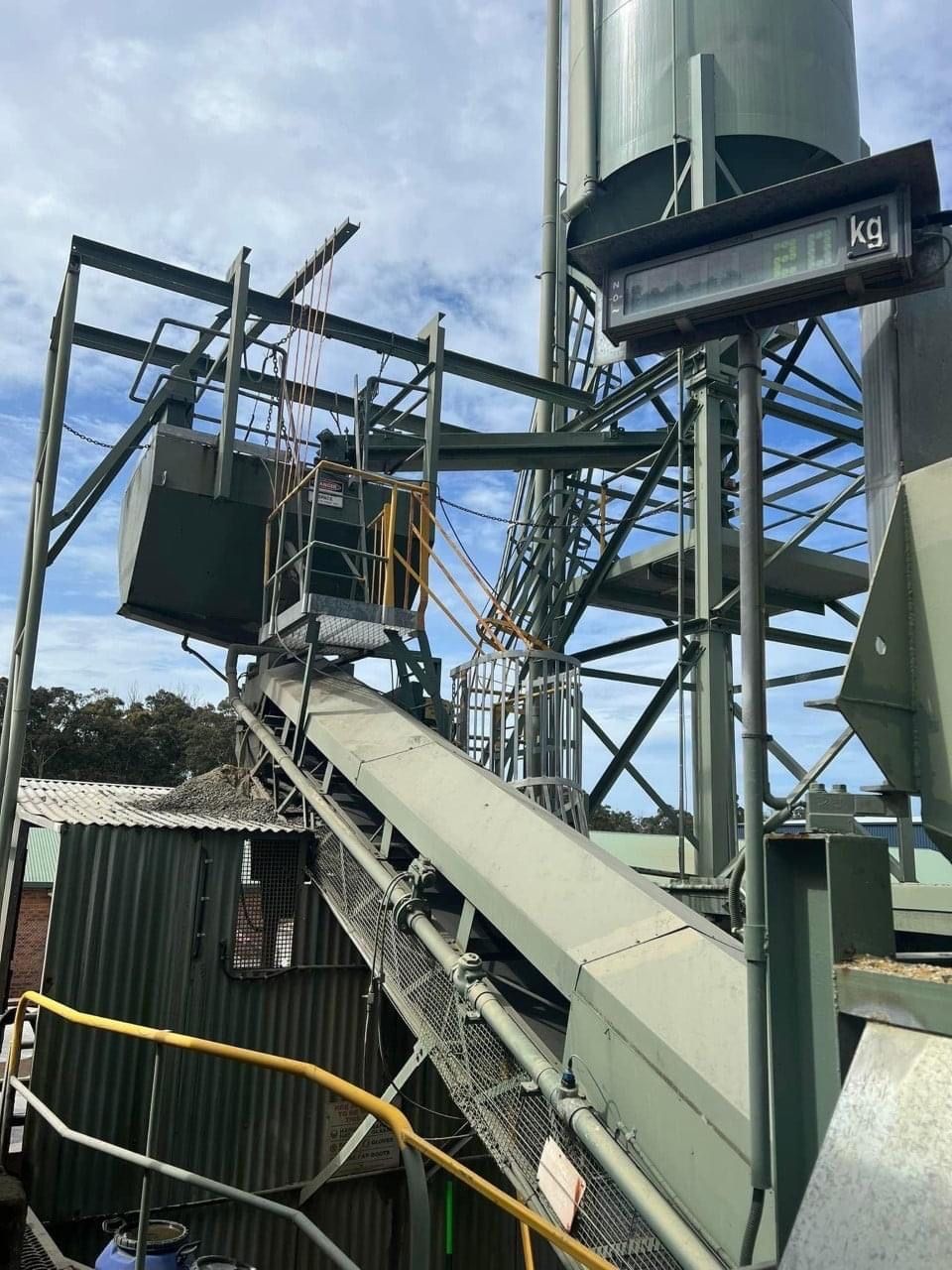 A Conveyor Belt In A Factory With A Silo In The Background — BayCoast Electrical & Control Solutions in Narooma, NSW