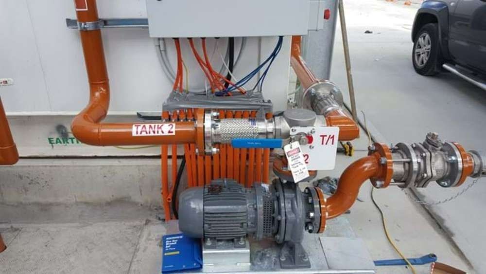 A Pump Is Sitting Next To A Wall With A Lot Of Pipes And Wires — BayCoast Electrical & Control Solutions In South Durras, NSW