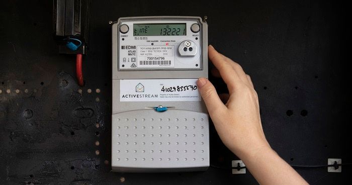 A Person Is Pressing a Button on An Electric Meter — Bay Coast Electrical & Control Solutions in Maloneys Beach, NSW