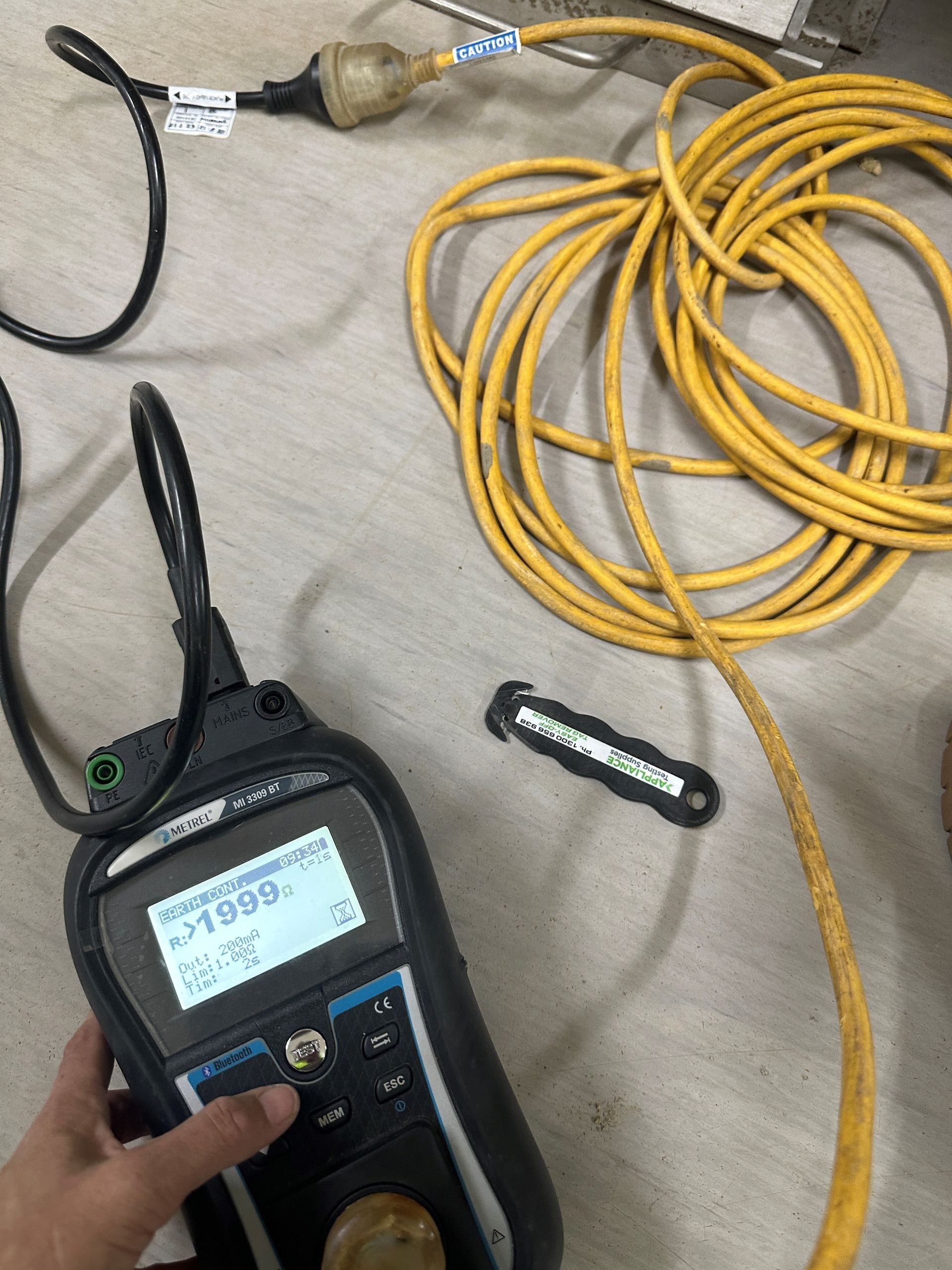 A Man Wearing Headphones Is Working On An Electrical Box — BayCoast Electrical & Control Solutions in Maloneys Beach, NSW