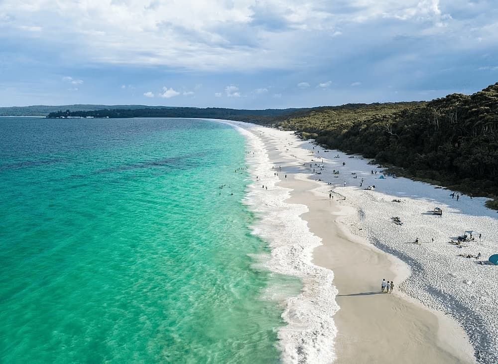 An Aerial View of A Long White Sandy Beach Surrounded by Turquoise Water — Bay Coast Electrical & Control Solutions in Maloneys Beach, NSW