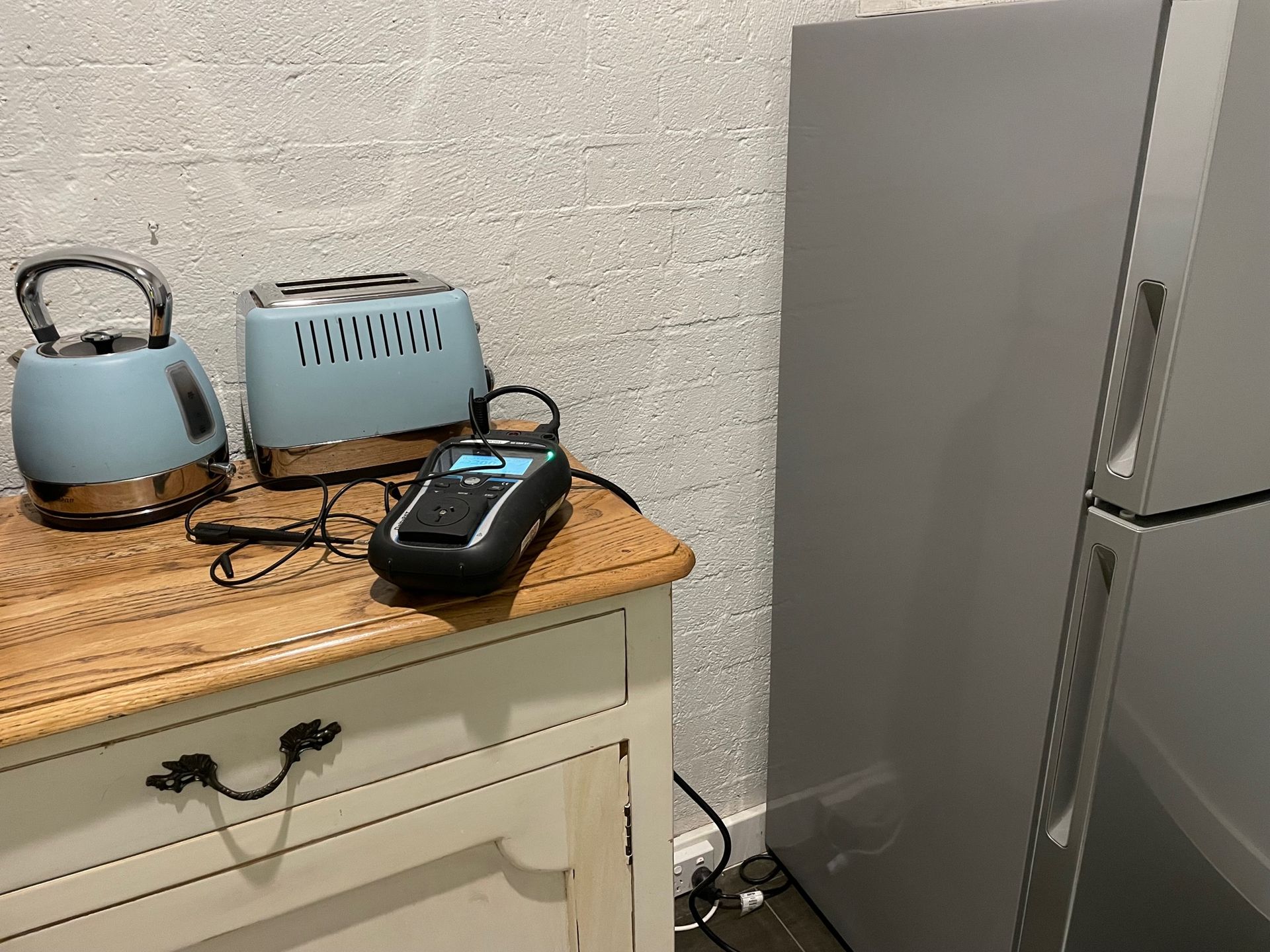 A Toaster And A Kettle Are On A Table Next To A Refrigerator — BayCoast Electrical & Control Solutions In South Durras, NSW