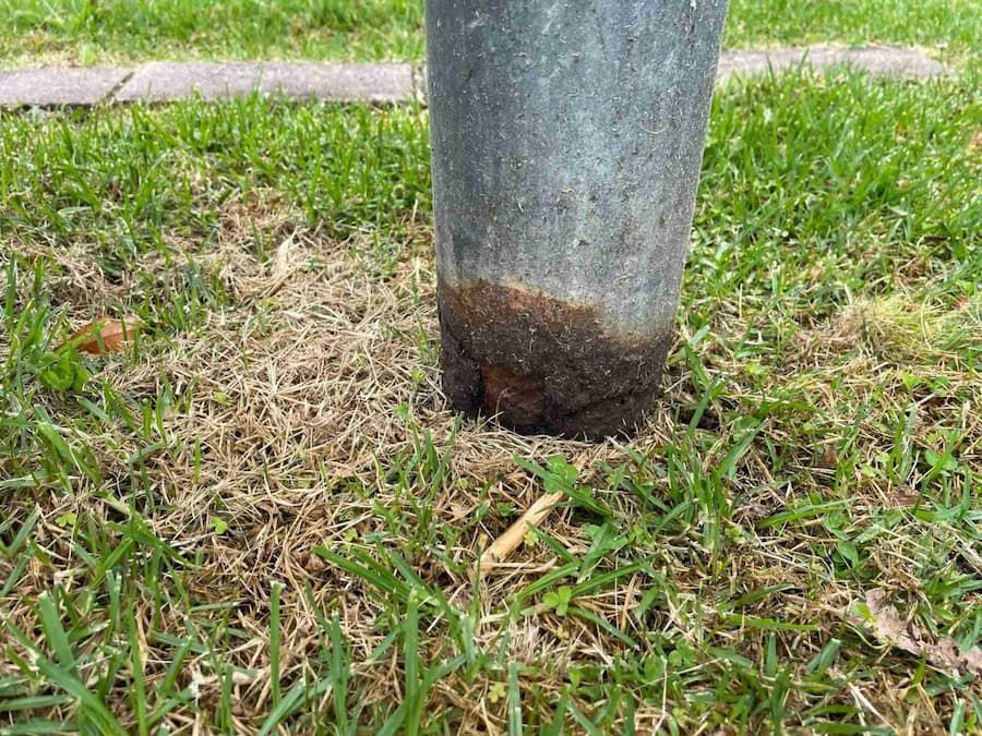 A Metal Pole Is Sitting in The Middle of A Lush Green Field — Bay Coast Electrical & Control Solutions in Maloneys Beach, NSW