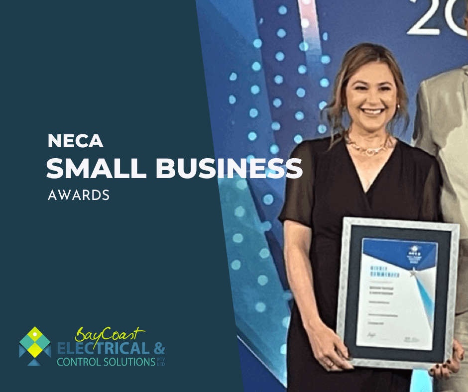 A Woman Is Holding A Framed Certificate In Front Of A Blue Background — BayCoast Electrical & Control Solutions in Maloneys Beach, NSW