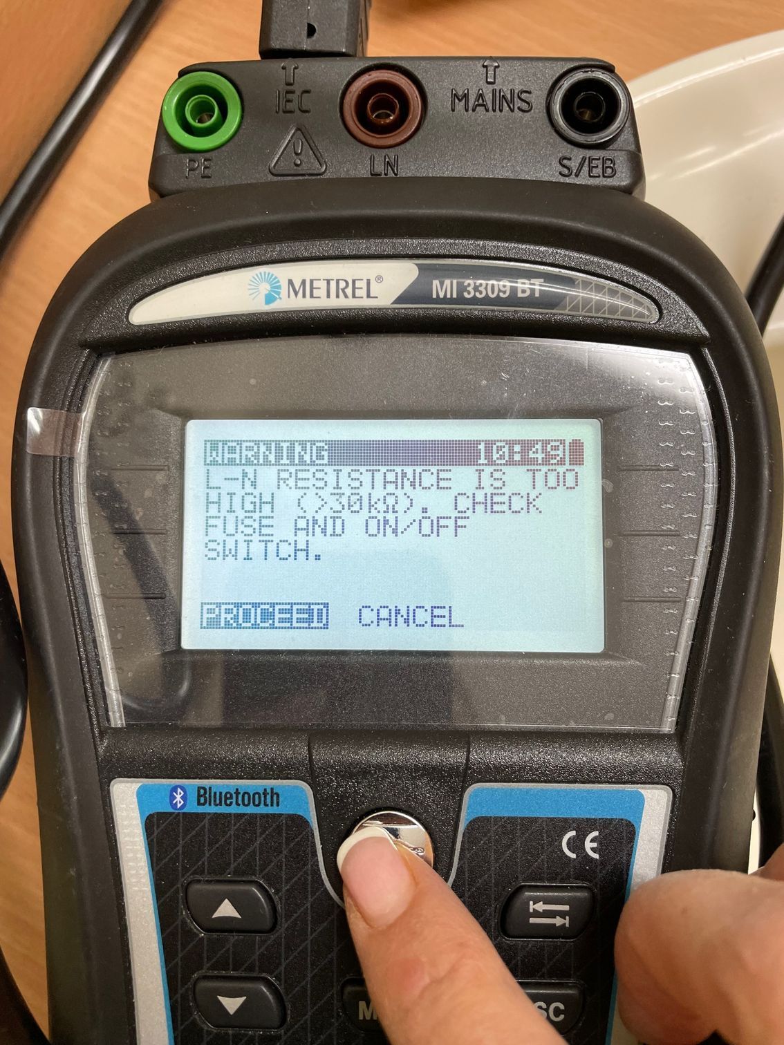 A Person Is Using A Multimeter To Test A Plug — BayCoast Electrical & Control Solutions in Maloneys Beach, NSW